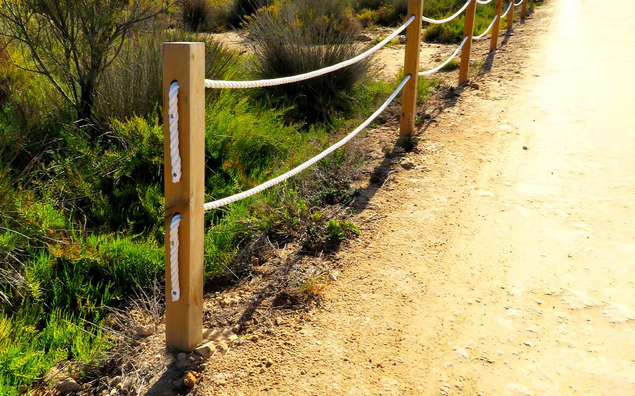 Postes de madera para valla que indica y asegura el camino
